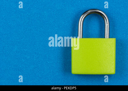 Green padlock isolated on blue background Stock Photo