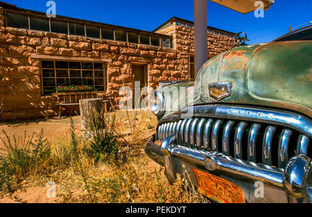 Old classic buick in front of a desert gas station from long ago. Stock Photo