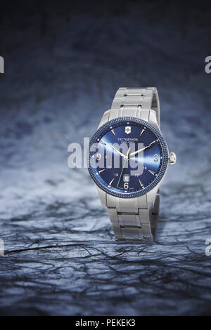 Blue Stainless Steel Victorinox Watch on Blue Background Stock Photo