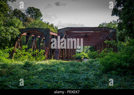 Rusty old railroad bridge that is abandoned in the forest Stock Photo