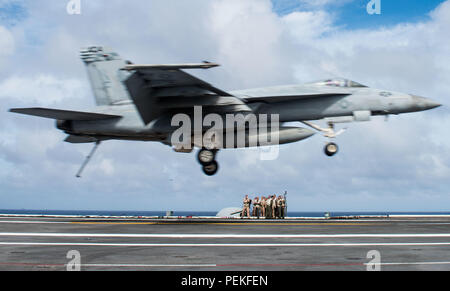 180815-N-OY799-0132 WATERS SOUTH OF JAPAN (August 15, 2018) Landing signal officers observe as an F/A-18E Super Hornet, assigned to Strike Fighter Squadron (VFA) 195, lands on the flight deck of the Navy’s forward-deployed aircraft carrier, USS Ronald Reagan (CVN 76). Ronald Reagan, the flagship of Carrier Strike Group 5, provides a combat-ready force that protects and defends the collective maritime interests of its allies and partners in the Indo-Pacific region. (U.S. Navy photo by Mass Communication Specialist 2nd Class Kenneth Abbate) Stock Photo