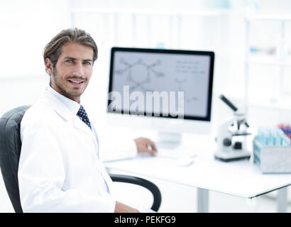 Male scientist sitting at table in laboratory Stock Photo