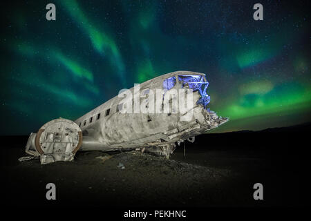 The crashed DC-3 Plane wreck with Northern Lights & Aurora Borealis at Solheimasandur, Iceland Stock Photo