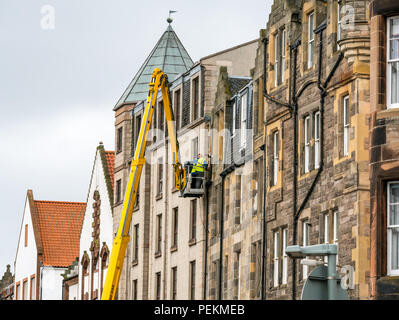 High level cherry picker with workmen repairing downpipe, The Shore, Leith, Edinburgh, Scotland, UK Stock Photo