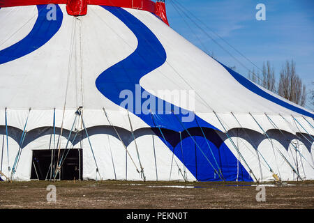 A blue striped circus tent in green nature. Stock Photo