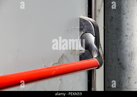 Closed up latch and door handle of emergency exit. Push bar and rail for panic exit. Stock Photo