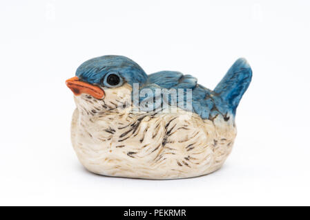 A vintage cute little ceramic blue bird figurine isolated on white. Stock Photo