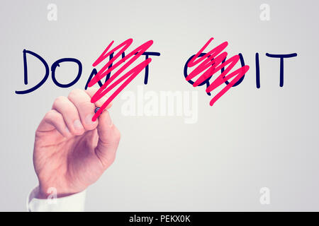 Dont Quit - Do It, conceptual image with a man scrubbing through letters in the words Dont Quit converting them to Do It with a red pen in a motivatio Stock Photo