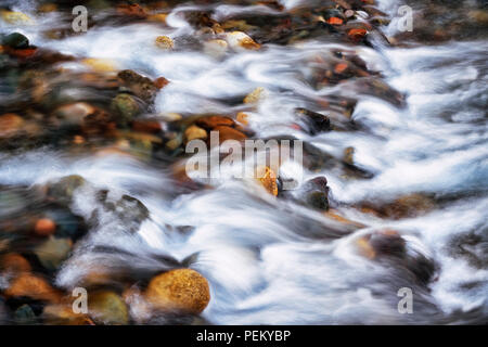 The Wild and Scenic Wallowa River rushes over colorful rocks on its journey to Wallowa Lake in NE Oregon’s Wallowa County. Stock Photo