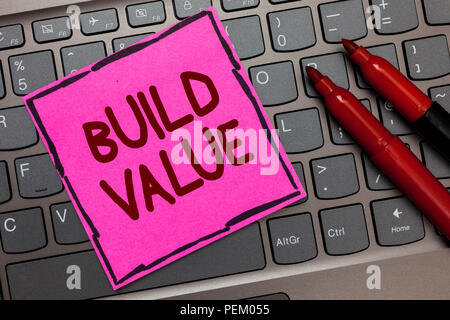 Text sign showing Build Value. Conceptual photo efficient enough way that it will generate profit after cost Pink paper keyboard Inspiration communica Stock Photo