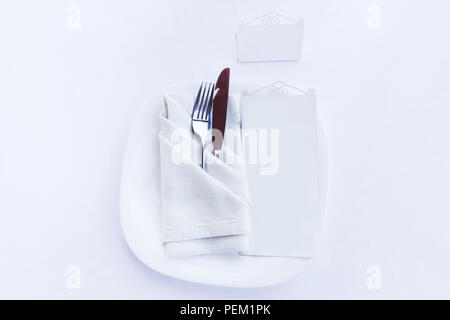 Plate, cutlery in textile napkin and menu plate isolated on white Stock Photo