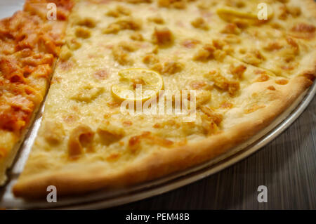 Large slices of cheese pizza with chicken francese topping Stock Photo