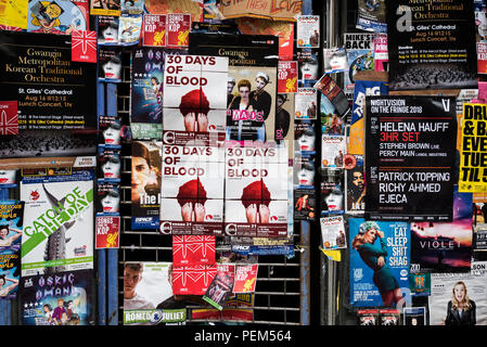 Posters stuck on the window of an empty shop advertising shows on the Edinburgh Fringe Festival, Edinburgh, Scotland, UK. Stock Photo