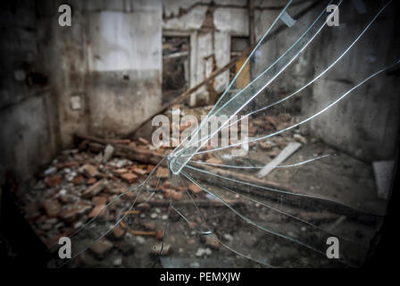 A broken window on an abandoned derelict house Stock Photo