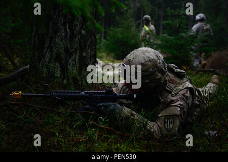 A Soldier assigned to the 15th Engineer Battalion, 18th Military Police Brigade, provides security during a live-fire convoy exercise at the 7th Army Joint Multinational Training Command’s Grafenwoehr Training Area, Grafenwoehr, Germany, Dec. 15, 2015.  This exercise is designed to prepare Soldiers to navigate through rough terrain while under fire. (U.S. Army photo by Pfc. Emily Houdershieldt/released) Stock Photo