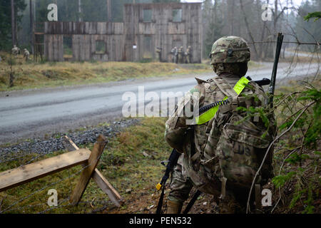 A Soldier assigned to the 15th Engineer Battalion, 18th Military Police Brigade, uses radio communication during a live-fire convoy exercise at the 7th Army Joint Multinational Training Command’s Grafenwoehr Training Area, Grafenwoehr, Germany, Dec. 15, 2015.  This exercise is designed to prepare Soldiers to navigate through rough terrain and clear buildings. (U.S. Army photo by Pfc. Emily Houdershieldt/released) Stock Photo