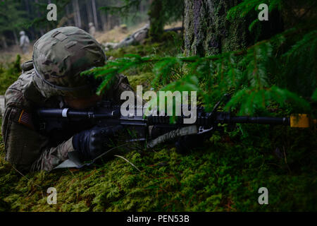 A Soldier assigned to the 15th Engineer Battalion, 18th Military Police Brigade, provides security during a live-fire convoy exercise at the 7th Army Joint Multinational Training Command’s Grafenwoehr Training Area, Grafenwoehr, Germany, Dec. 15, 2015.  This exercise is designed to prepare Soldiers to dismount a vehicle and navigate through rough terrain while under fire. (U.S. Army photo by PFC Emily Houdershieldt/released) Stock Photo