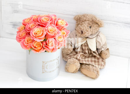 Roses in a round box and a bear. Romantic gift. Roses in a Hat Box Stock Photo