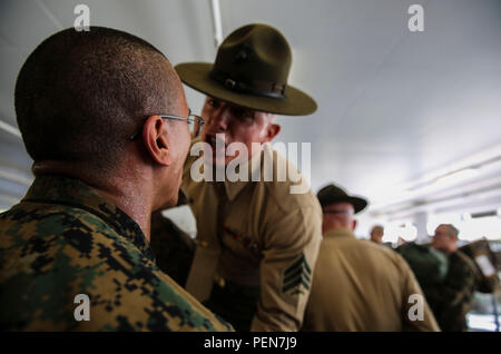 Sergeant Preston T. Brown, India Company, 3rd Recruit Training Battalion, corrects a recruit during pick up at Marine Corps Recruit Depot San Diego, Dec. 18. In the first hours with their drill instructors, recruits learn the rules and regulations of recruit training, regarding everything from how to act in the squad bay to how to speak to the drill instructors. Annually, more than 17,000 males recruited from the Western Recruiting Region are trained at MCRD San Diego. India Company is scheduled to graduate March 11. Stock Photo