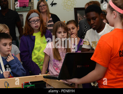 At Ellsworth Air Force Base, South Dakota, on December 21, 2015, a robotics competitor demonstrated toy robot construction and operation to children at the Youth Center. The session introduced STEM concepts, including engineering, coding, and mathematics applications. Participants learned how programming and mechanical assembly control robot movement. The demonstration provided hands-on learning, encouraged problem-solving, and engaged students in science and technology activities while promoting curiosity and education in robotics. Stock Photo
