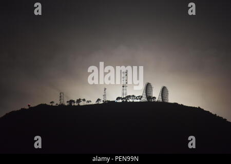 Moon setting behind communication and broadcasting equipments mounted on the summit of Mount Sto Tomas in Tuba, Benguet, Philippines Stock Photo