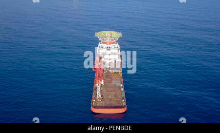 Aerial image of a Medium size red Offshore supply ship with a Helipad and a large crane Stock Photo