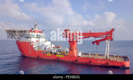 Aerial image of a Medium size red Offshore supply ship with a Helipad and a large crane Stock Photo