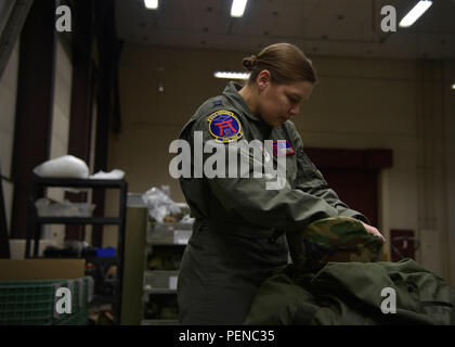 U.S. Air Force Capt. Christina Gallo, the Aircrew Flight Equipment Flight commander with the 35th Operations Support Squadron, inspects her helmet at Misawa Air Base, Japan, Jan. 6, 2016. Individual protective equipment Airmen issue all in-processing active-duty members a training C-bag, consisting of a joint service lightweight integrated suit technology coat and trousers, flak vest, M50 gas mask, chemical boots, chemical gloves, glove inserts, web belt, canteen, helmet and suspenders. (U.S. Air Force photo by Senior Airman Deana Heitzman)