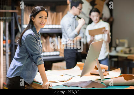 Confident leather craftspeople working in studio Stock Photo