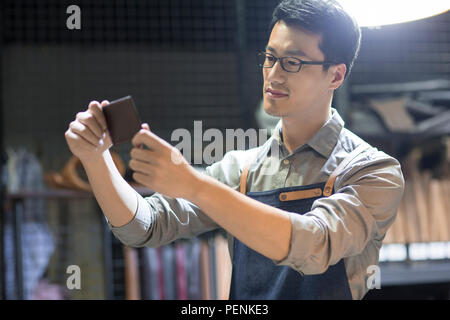 Young leather craftsman working in studio Stock Photo