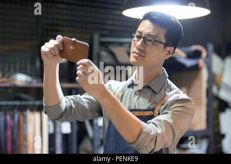 Young leather craftsman working in studio Stock Photo