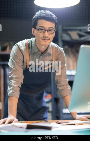 Young leather craftsman working in studio Stock Photo