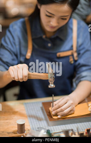 Young leather craftswoman working in studio Stock Photo