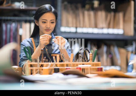 Young leather craftswoman working in studio Stock Photo