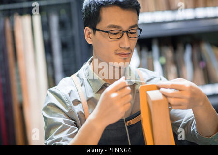 Young leather craftsman working in studio Stock Photo
