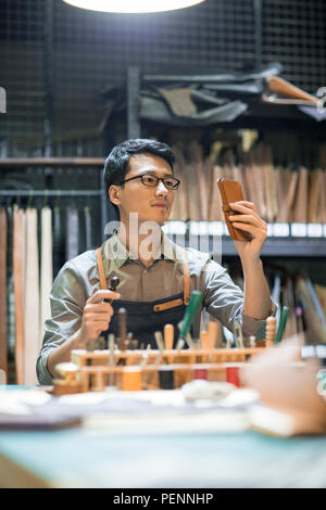 Young leather craftsman working in studio Stock Photo