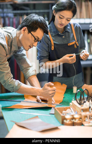 Young leather craftspeople working in studio Stock Photo