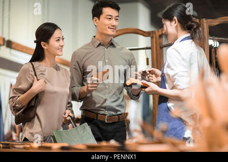 Happy young couple shopping in leather shop Stock Photo