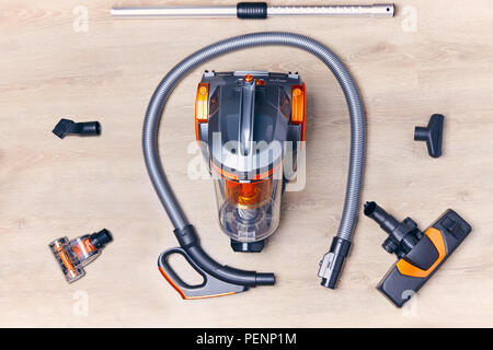 Top view of a modern vacuum cleaner with a container with nozzles and a hose spread out around it Stock Photo