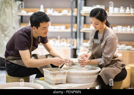 Potter teaching young woman making pottery Stock Photo