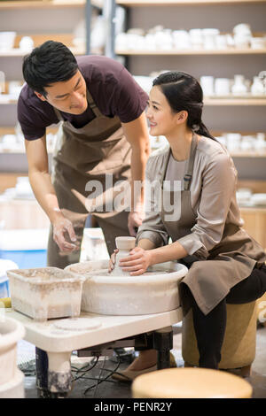 Potter teaching young woman making pottery Stock Photo