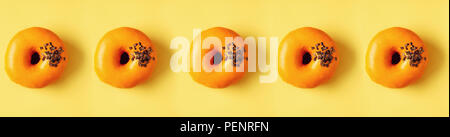 Flat lay donuts pattern on pastel orange background. Top view. Square crop. Sweet doughnut texture, copy space. Stock Photo