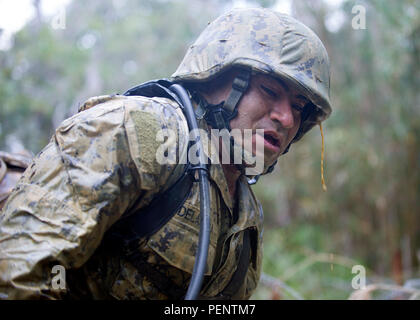 160112-N-YG415-116 OKINAWA, Japan (Jan. 12, 2016) Construction Mechanic 2nd Oscar C. Delarosa assigned to Naval Mobile Construction Battalion (NMCB) 3, gasp for air after crawling through muddy trenches during a 3.8-mile obstacle course as part of an obstacle course at the Jungle Warfare Training Center (JWTC), located in the Northern Training Area on the island of Okinawa. NMCB 3 is deployed to several countries in the Pacific area of Operations conducting construction operations and humanitarian assistance projects. (U.S. Navy photo by Mass Communication Specialist 1st Class Michael Gomez/ R Stock Photo