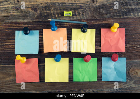 Bunch of colored sticky notes on the wooden background. Stock Photo