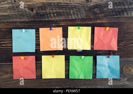 Bunch of colored sticky notes on the wooden background. Stock Photo