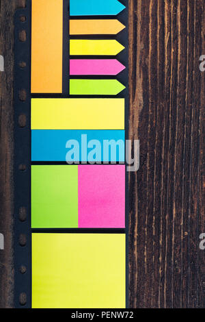 Bunch of colored sticky notes on the wooden background. Stock Photo