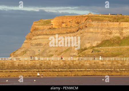 East Cliffs on the east side of Whitby harbour entrance, viewed over the west pier from beach, north Yorkshire, England UK Stock Photo