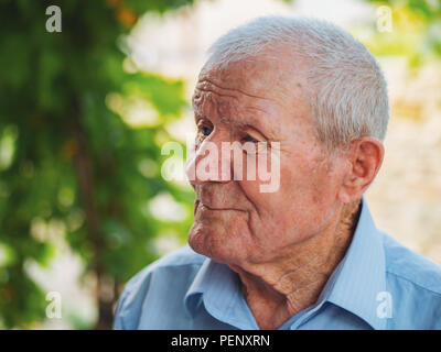 Very old man portrait. Grandfather relaxing outdoor at summer. Portrait: aged, elderly, senior. Close-up of old man sitting alone Stock Photo