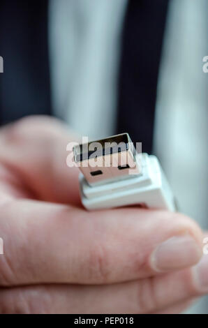 Closeup of a male hand holding usb key towards you. Stock Photo