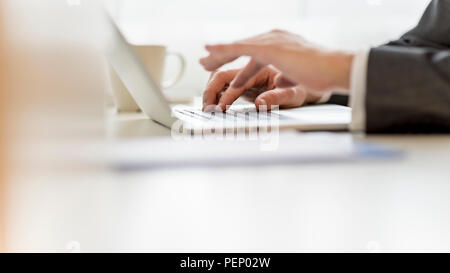 Closeup of businessman hands using laptop computer with one of the hands blurred. Stock Photo